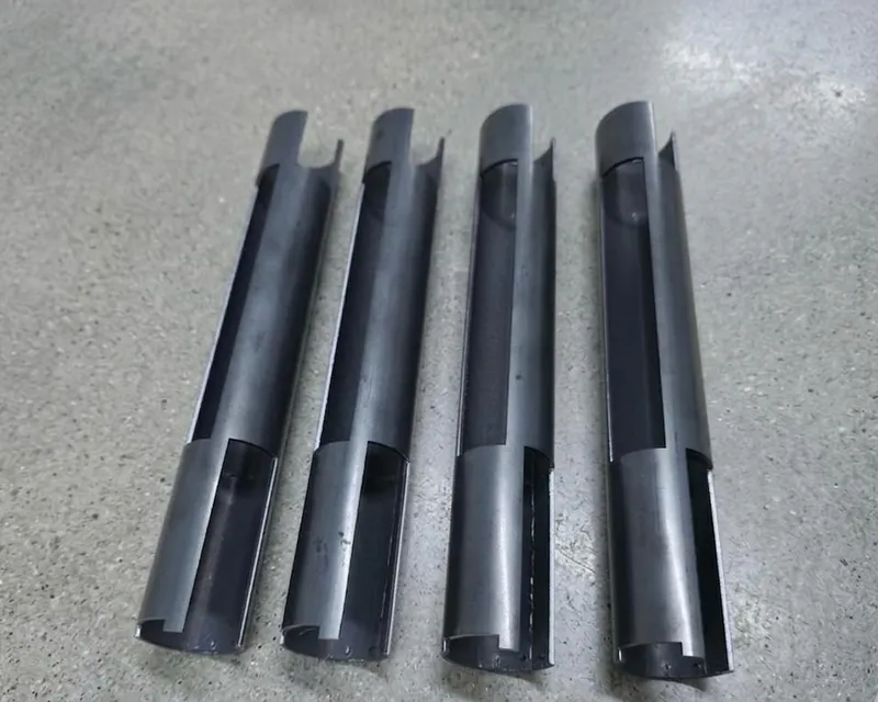 Four steel tube sections with curved, notched scoop-cut ends